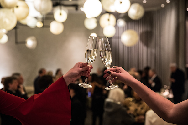 Champagne glasses toasting with restaurant in the background