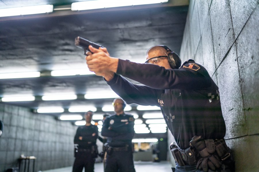 Police training in shooting gallery with short weapon.