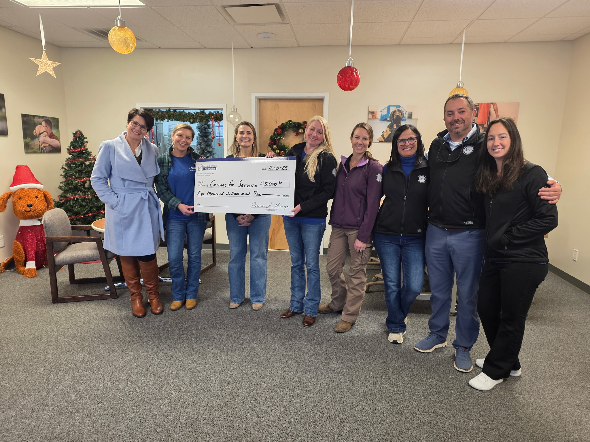 Mungo employees posing with a giant check.