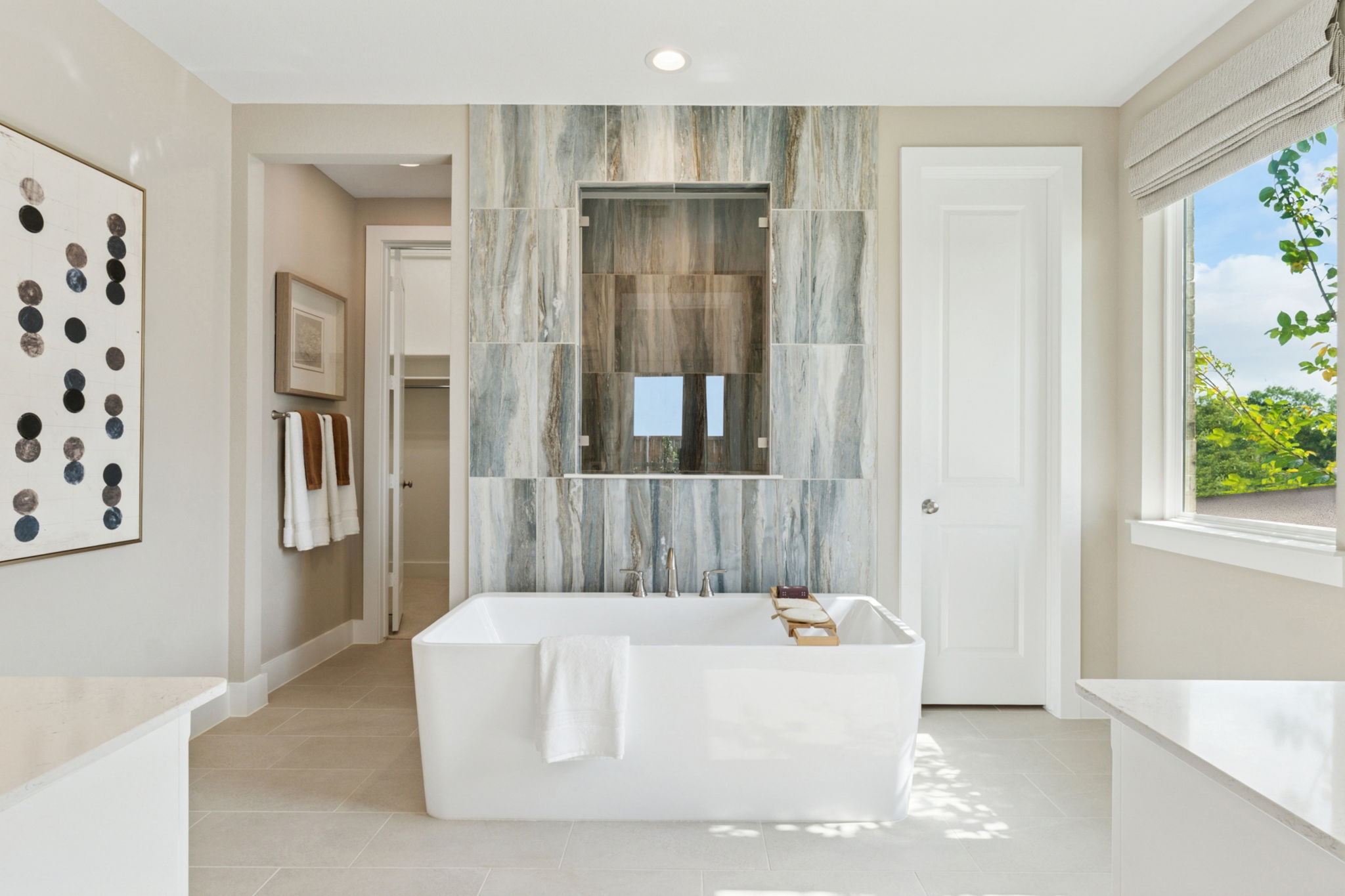 Beautiful primary bathroom including freestanding tub centered in the room, and a walk-in shower behind