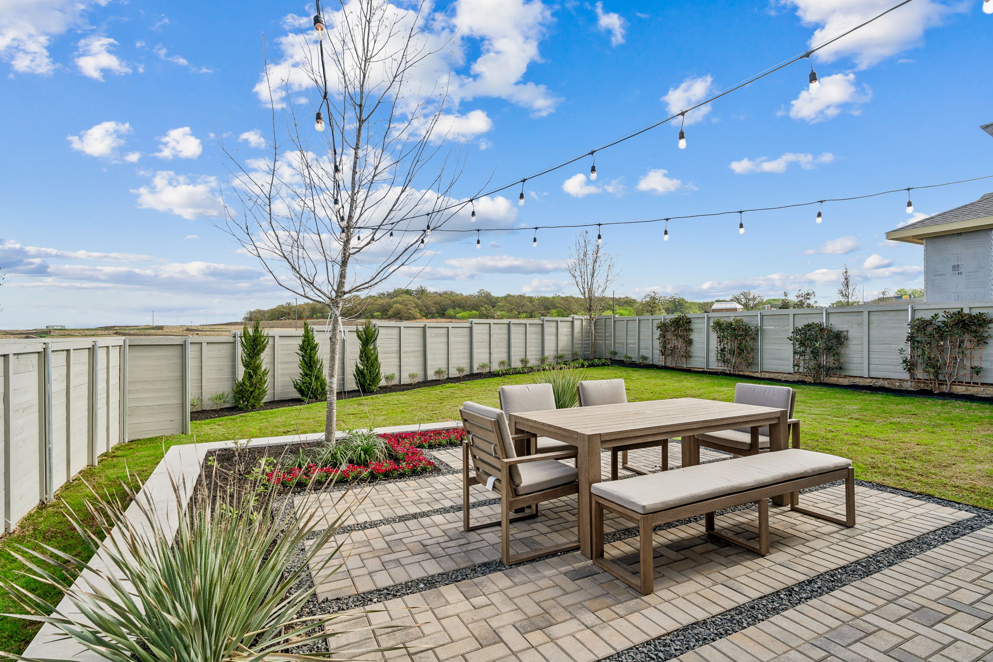 Expansive backyard space with strung lights and patio furniture