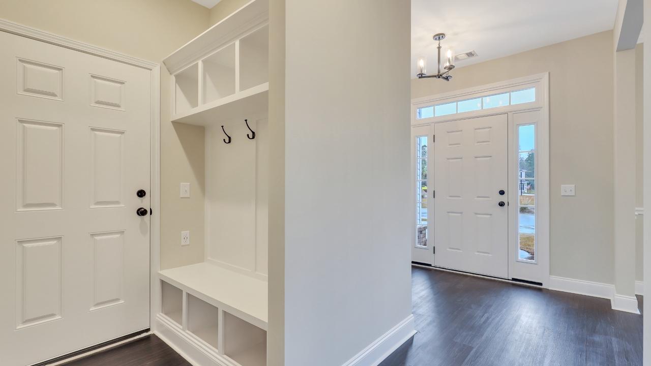 Built-in mudroom bench with hooks and cubbies in an Ernest Homes entryway