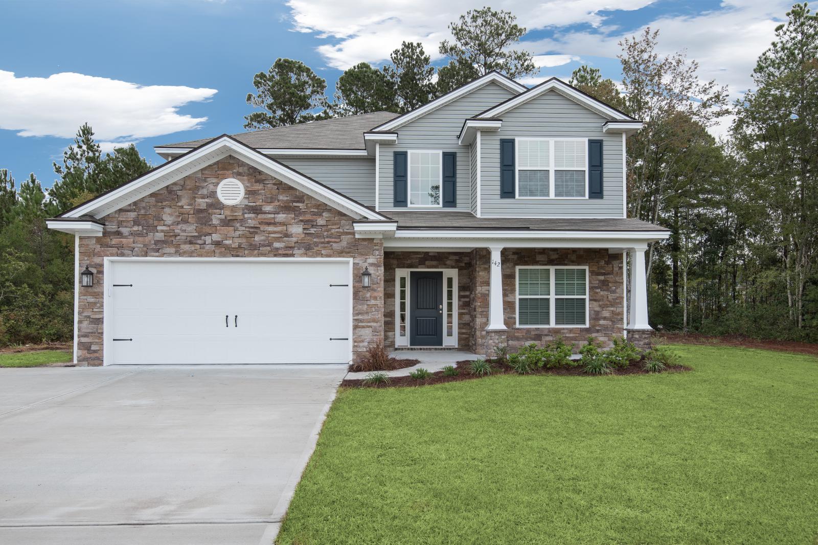 Front exterior of The Kingston two-story home by Ernest Homes with stone accents and two-car garage in Wexford.