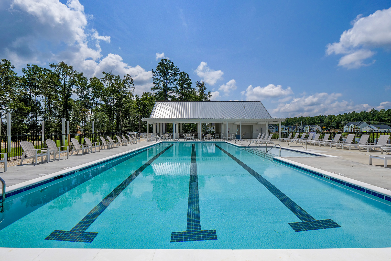 A swimming pool with chairs on a bright day.