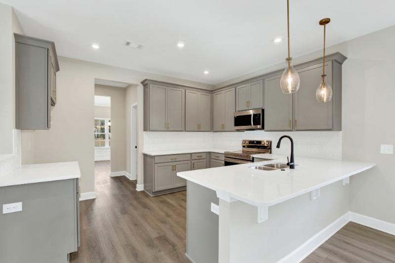 Kitchen detail at 245 James Drive with herringbone backsplash and white quartz counters