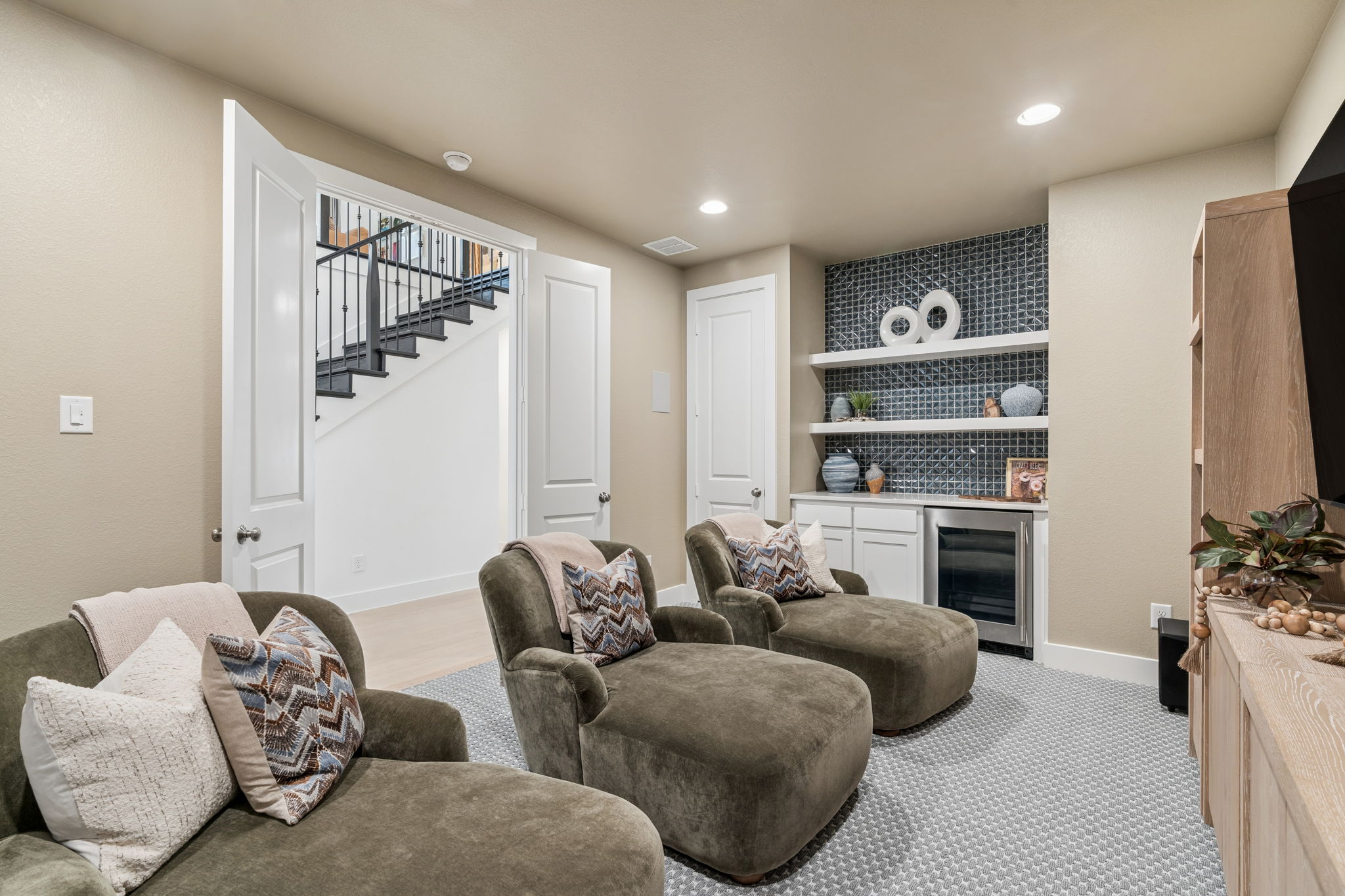Cozy media room with built-in shelves and wet bar