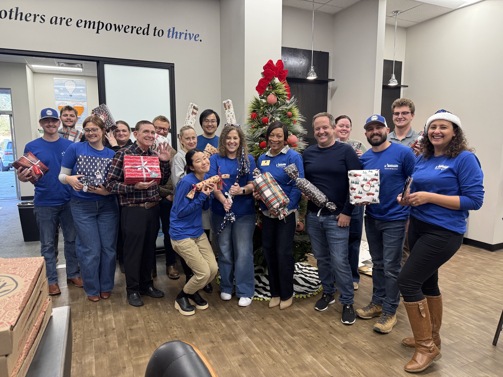 Mungo employees smiling holding wrapped gifts.