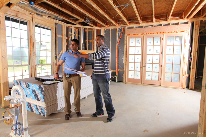 Homeowner walks through their home mid-build with their construction manager.