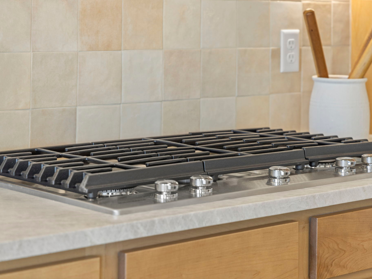 6-range cooktop against a stylish and warm toned backsplash