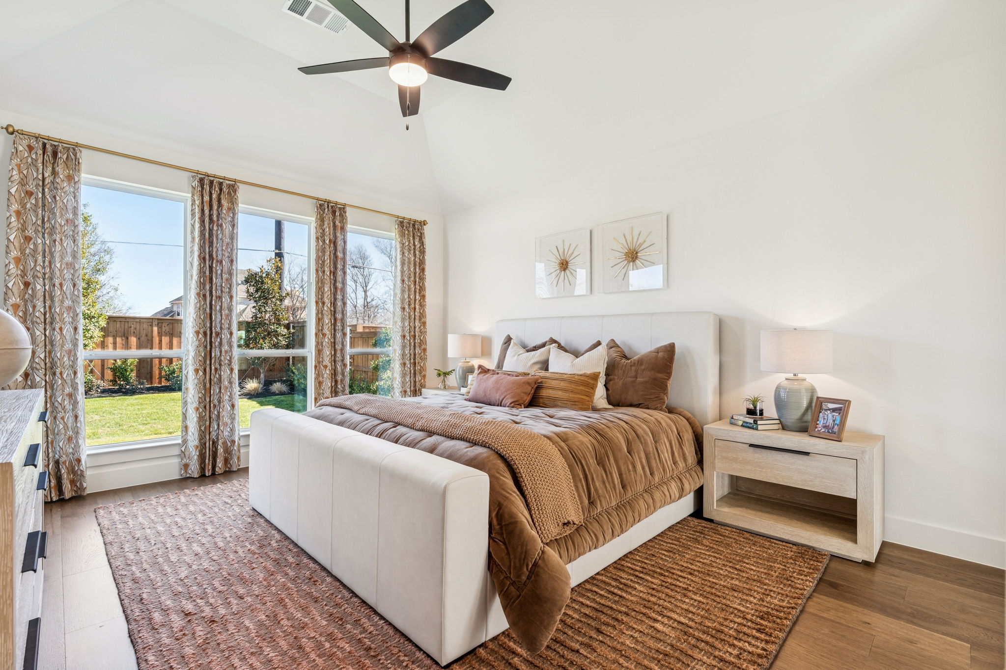 Warm-tone decorated primary bedroom with floor-to-ceiling windows