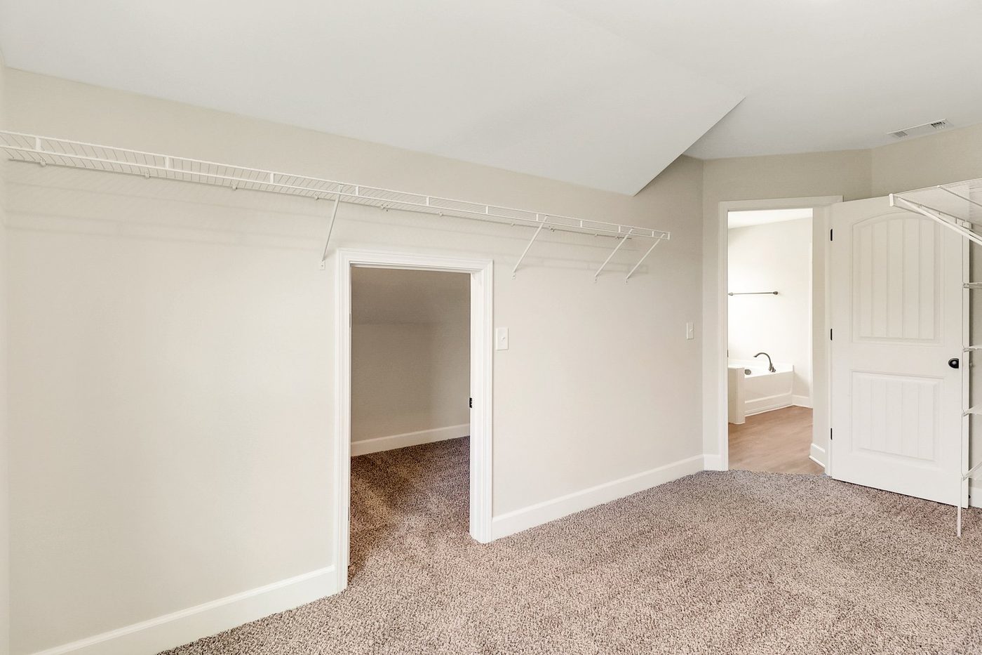 Additional heated storage space with shelving near a laundry room in a new home