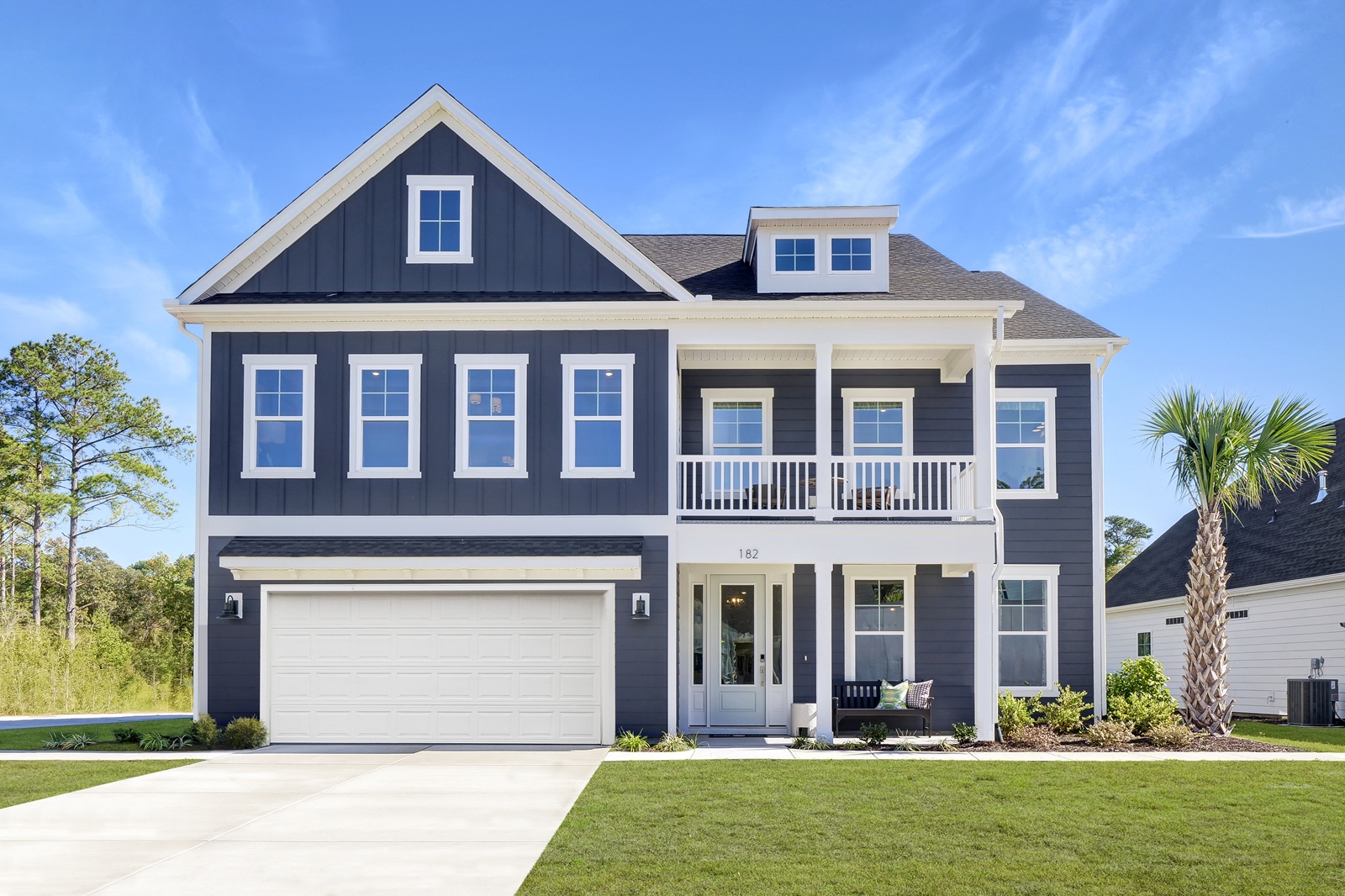 A large, blue home with two porches and a two-car garage.