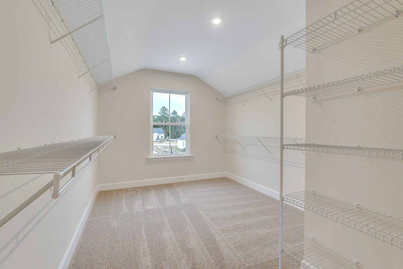 Large walk-in closet with wire shelving and natural light in a new construction home
