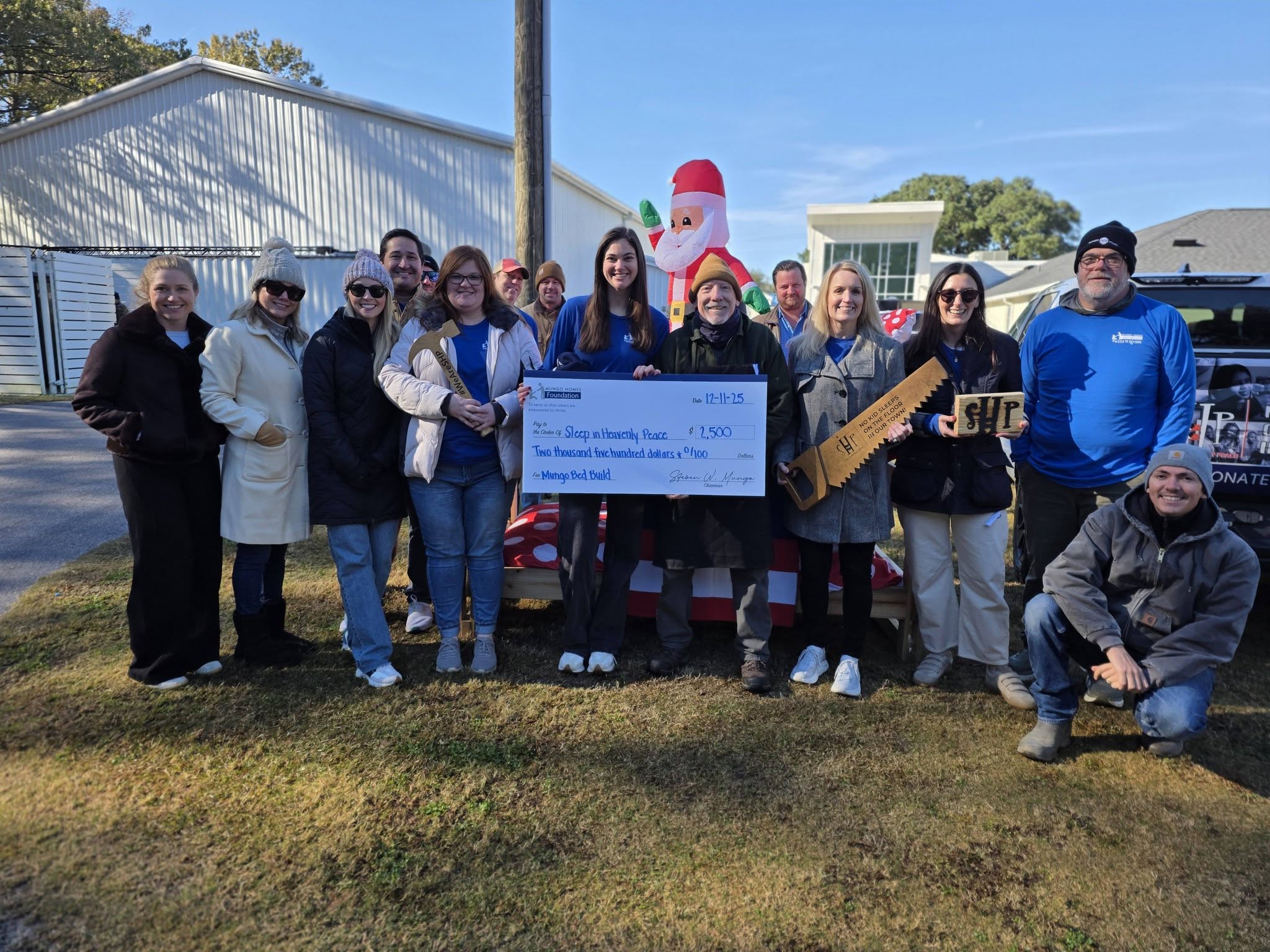 A group of Mungo employees presenting a check to Sleep in Heavenly Peace.