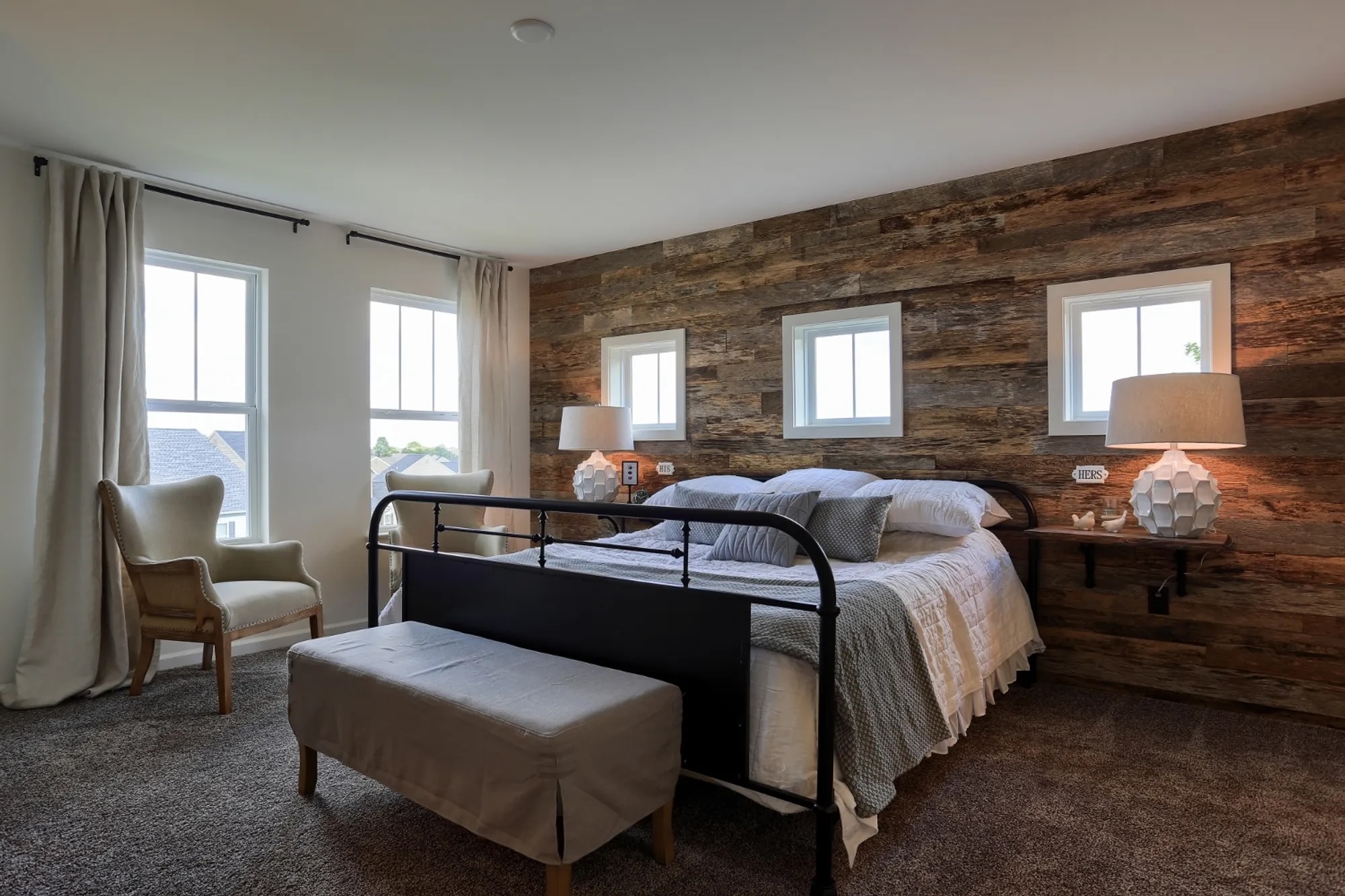 A farm house style bedroom with wood accent wall in a Garman Builders home