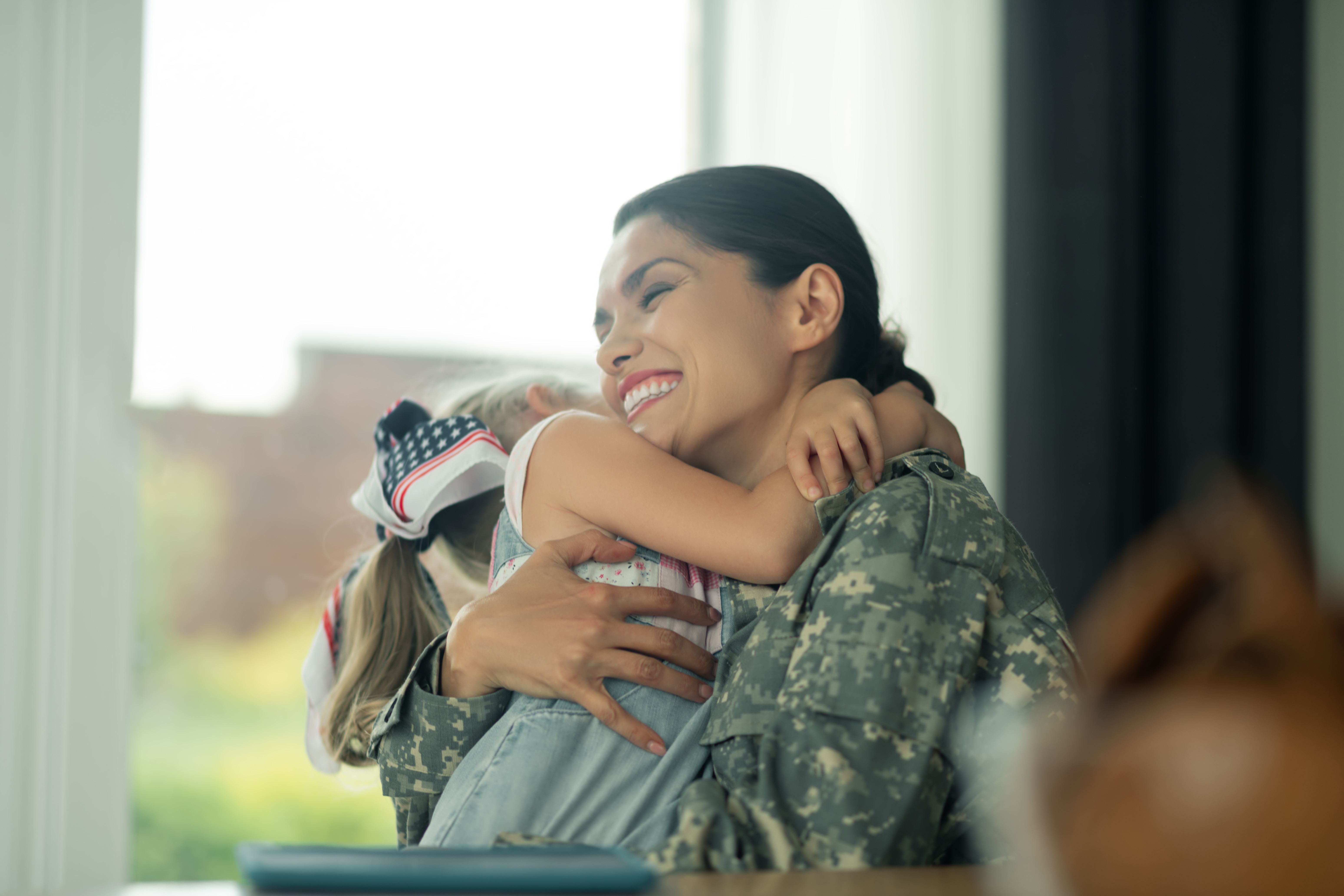 Military Mom hugging her daughter | Adobe Stock Image
