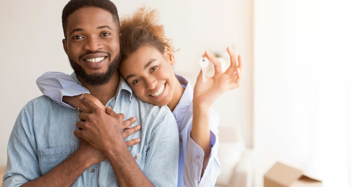 Stock image of two people holding the keys to their new home.