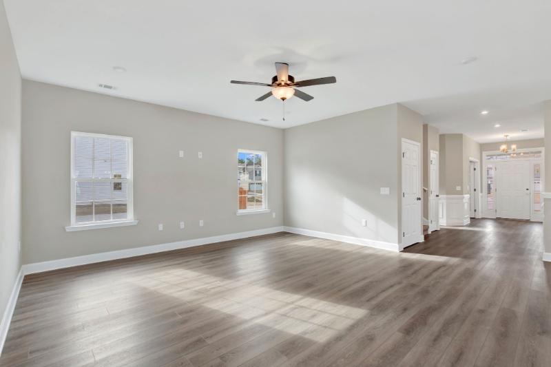 Open living room at 245 James Drive in Richmond Hill GA with luxury plank flooring and natural light