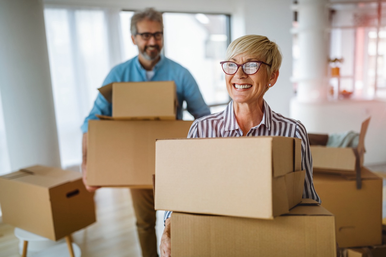 Two Older Adults Carrying Moving Boxes