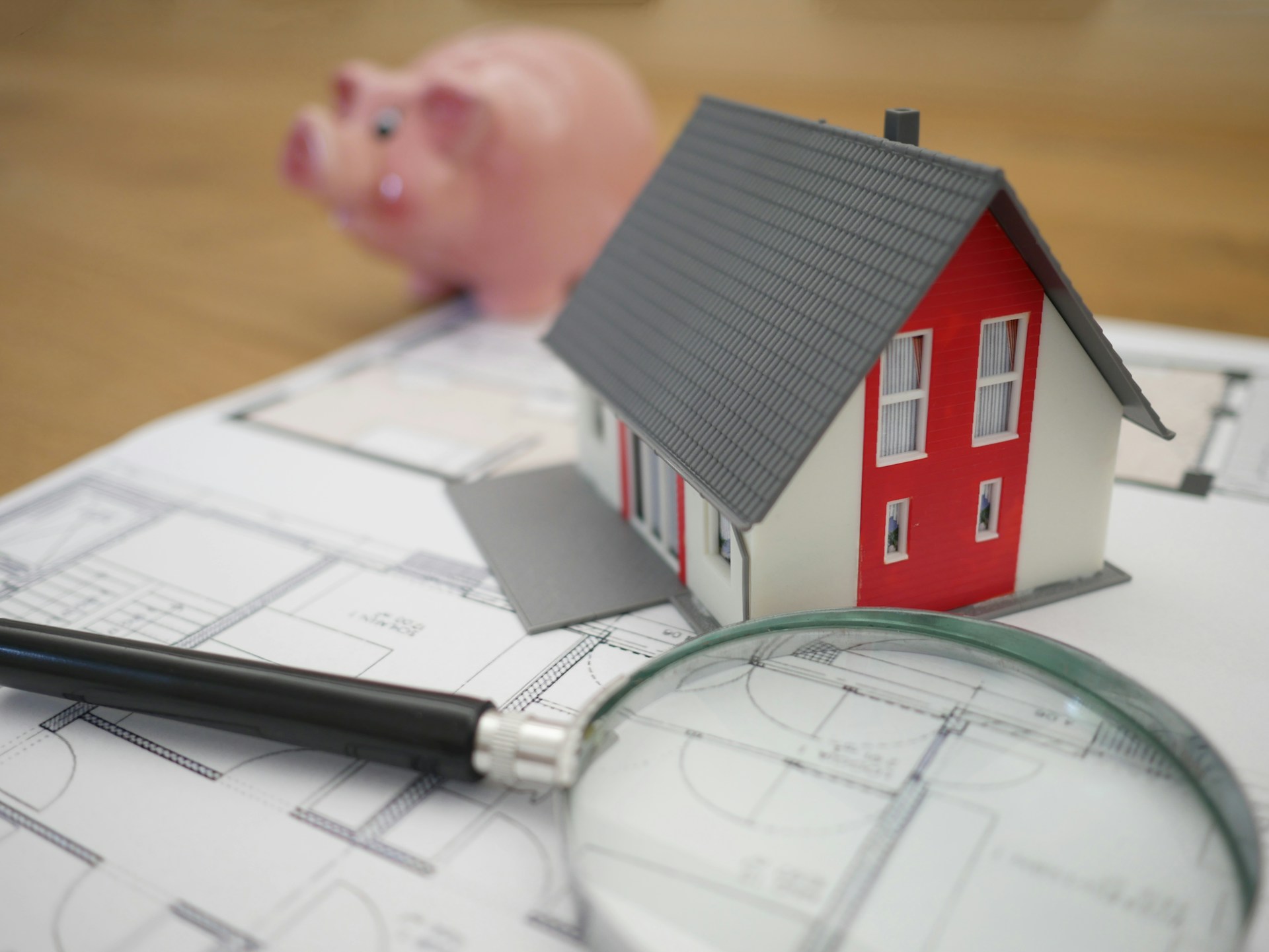 White and red wooden house beside grey framed magnifying glass