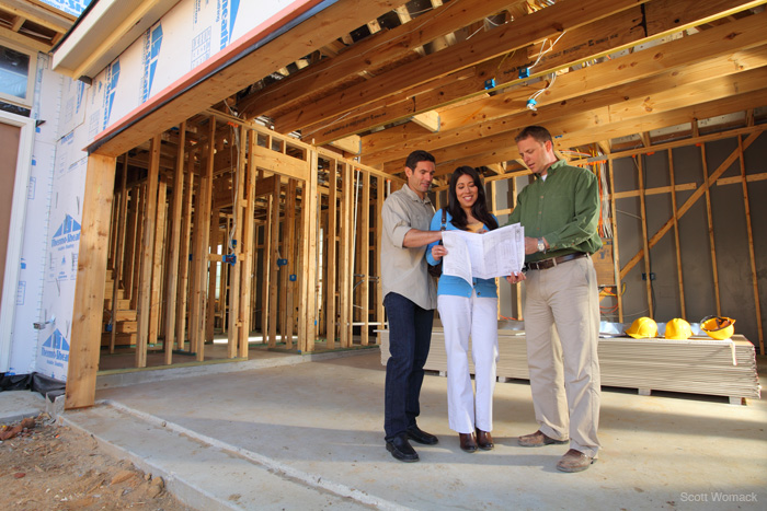 Image of construction manager talking their homeowners through the stage of construction with their new home.