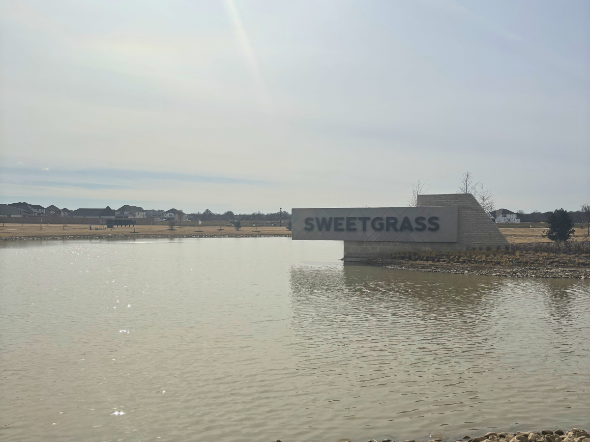 Large stone model stretching out over a large lake, surrounded by a quaint neighborhood.