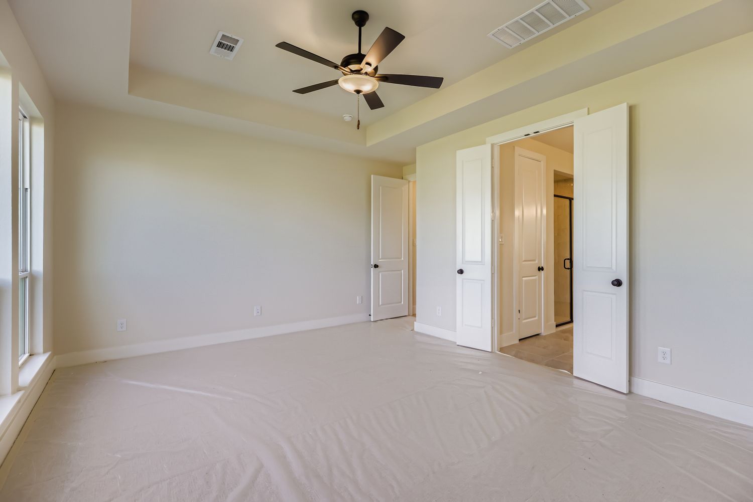 main bedroom with doors leading to main bathrooms