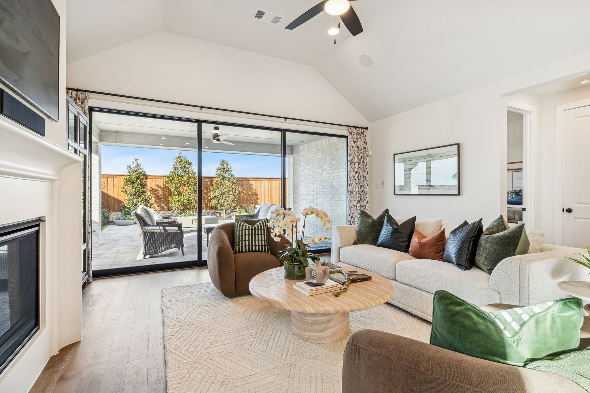 Cozy family room complete with fireplace, and a wall-mounted tv, with sliding glass doors that open to a covered patio