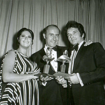 Merle Haggard won the first ACM Entertainer of the Year at the 6th ACM Awards, beating Johnny Cash, Glen Campbell, Elvis Presley, and Charley Pride. This made him the first Triple Crown winner, having also won Most Promising Male Vocalist in 1965.  