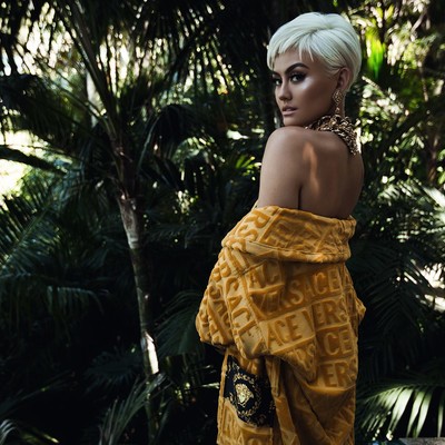Agnez Mo in a Versace Outfit Outside. Agnez Mo in a draping Versace outfit in front of trees outside.