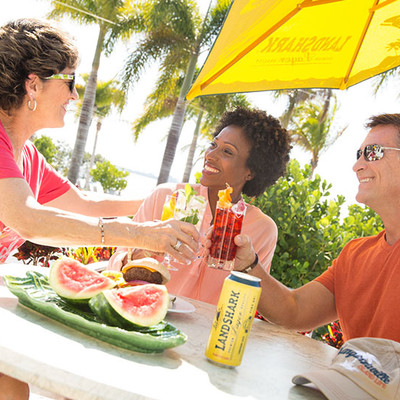 Two women and a man relaxing on the street at the table