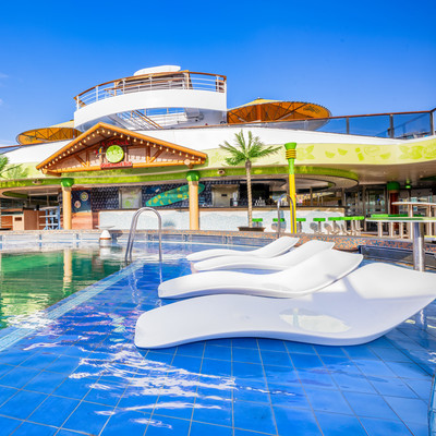 View of lounge chairs by the 5 O'Clock Somewhere Pool on Islander ship