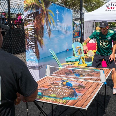 Two people playing ping pong in pickleball fashion