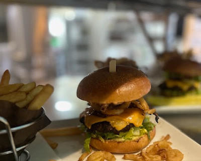 Photo of juicy bacon cheeseburger served with french fries on the side