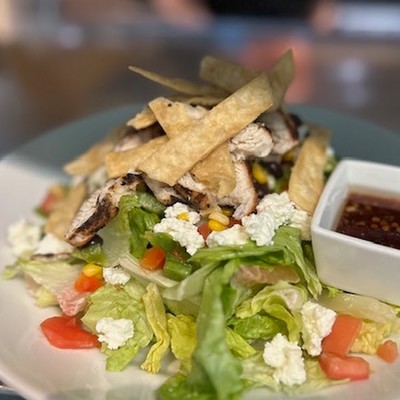 Photo of chicken Cobb salad with feta cheese, tomatoes, and crispy tortilla strips