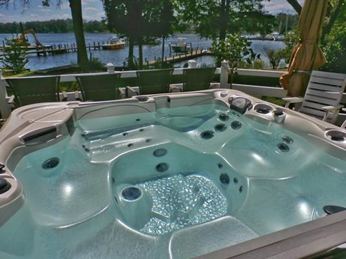 a customer photograph of their caldera spa on a lake front patio