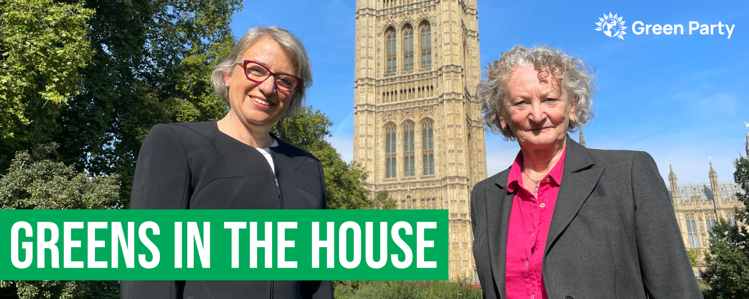 Photo of Natalie Bennett and Jenny Jones outside Parliament with text that reads:   Greens in the House.   With Green Party House of Lords logo in top right.