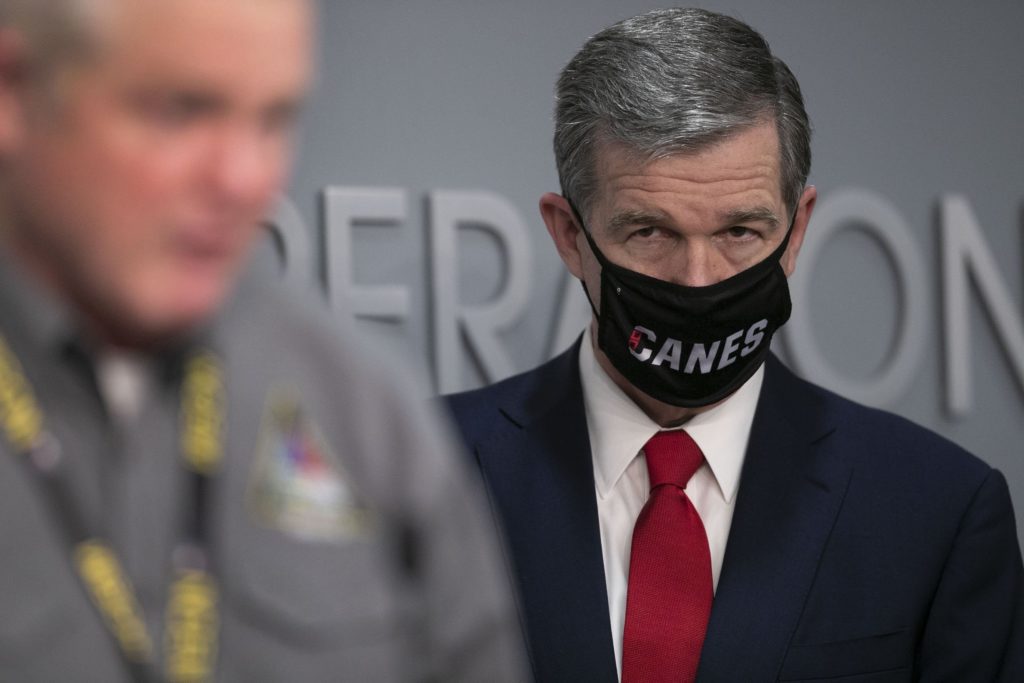 North Carolina Governor Roy Cooper listens to Mike Sprayberry, Director of Emergency Management, during a press briefing on the COVID-19 virus and vaccination efforts in March at the Emergency Operations Center in Raleigh, N.C. (Robert Willett/The News &amp; Observer via AP)