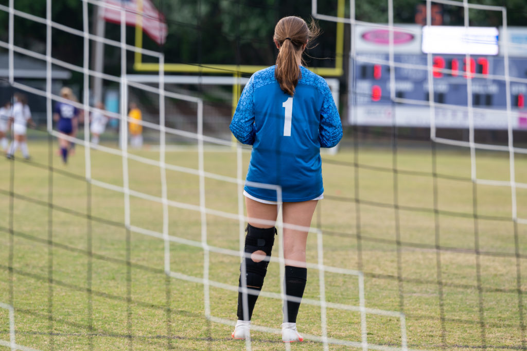 A high school goalie tends her post at the Millbrook High School versus Broughton High School soccer game in spring of 2021.  Photo by Maya Reagan, Carolina Journal