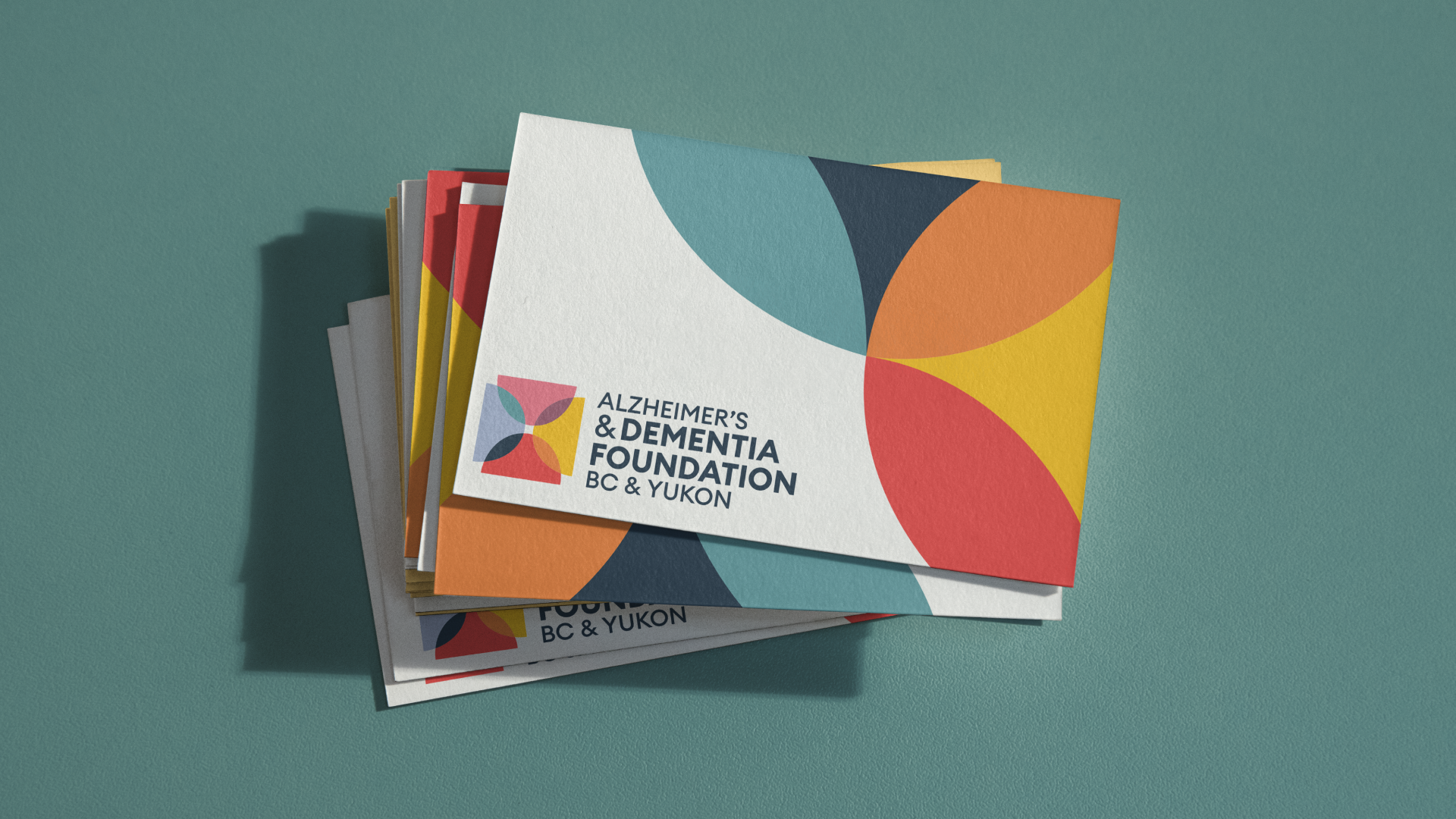 Stack of Alzheimer’s & Dementia Foundation stationery featuring the colourful geometric identity.