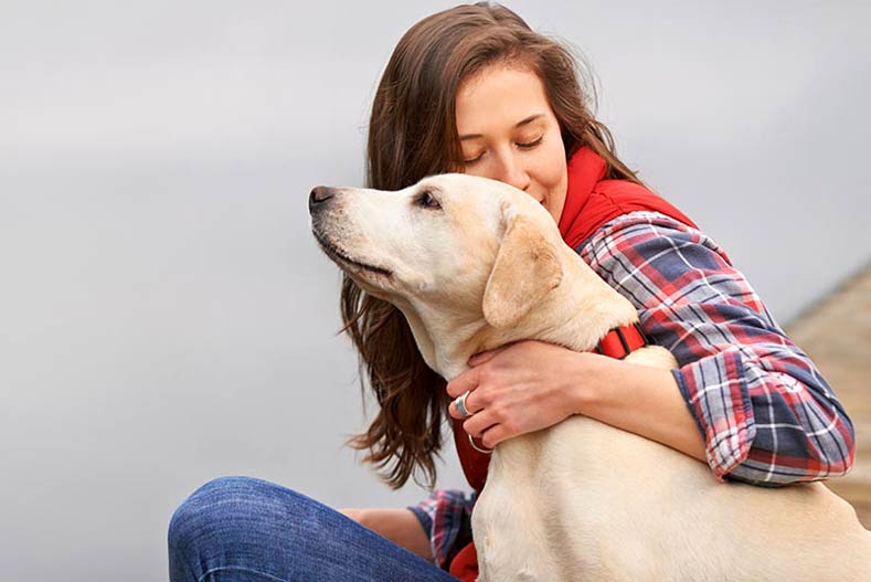 Woman outside with yellow labrador retriever