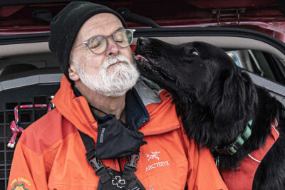 Lincoln sneaks a quick smooch with his handler Jon Izant during a break in a Saturday Search Dog training session in Tacoma, Washington.