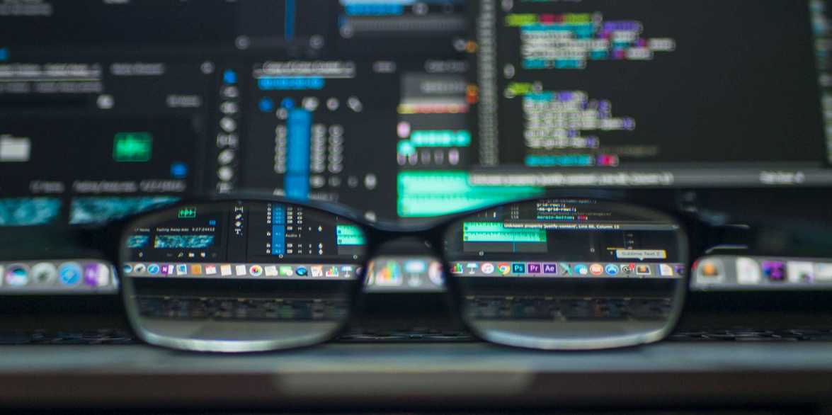 peering through eyeglasses set on a laptop