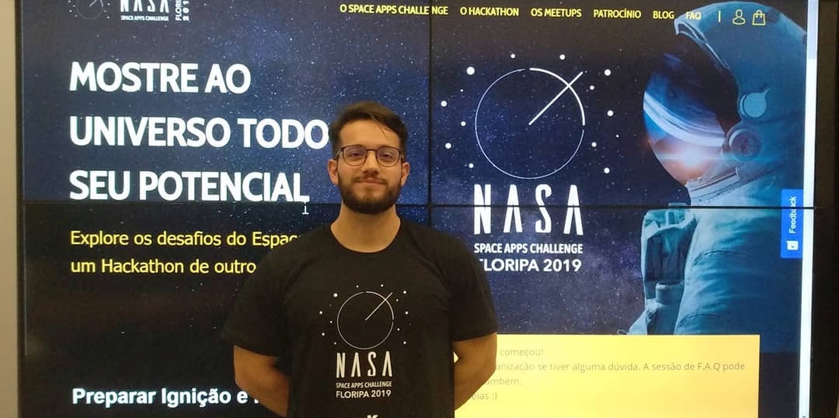 Carlos standing in front of NASA sign