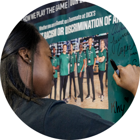 Woman signing a wall with a team photo