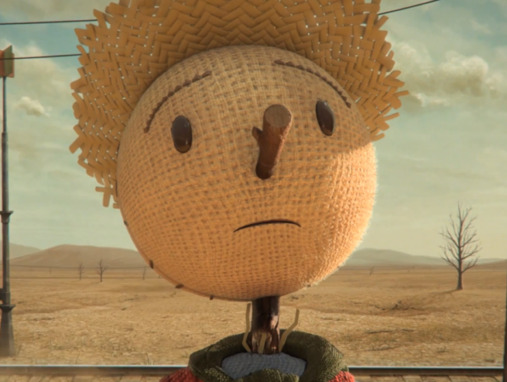 Espantapájaros con expresión triste en un campo seco, símbolo de la agricultura sostenible y la necesidad de cultivar un mundo mejor.