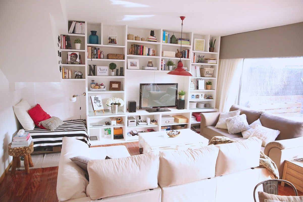 Sala comedor moderna con estantería blanca y sofá en tonos crema