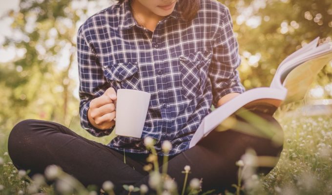 Joven disfrutan la lectura al aire libre