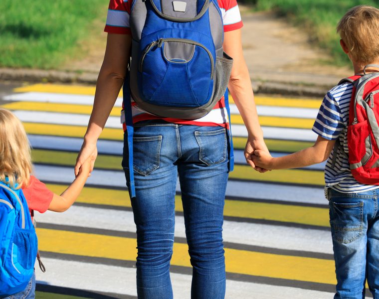 madre yendo con los hijos a actividades extracurriculares con mochilas