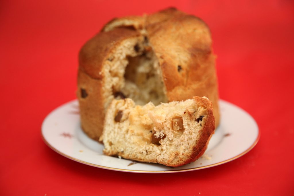 Pan dulce casero con frutas secas sobre un plato blanco.